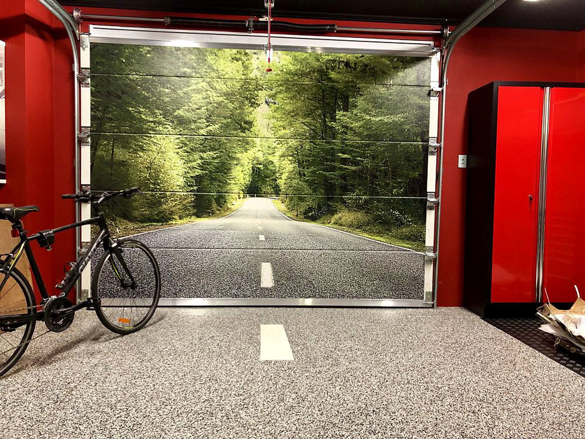 Sectional garage door printed edge to edge with a photorealistic forest road