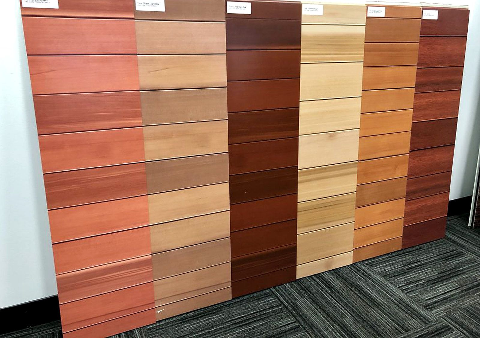 Sample panels showing photorealistic timber grains printed on steel