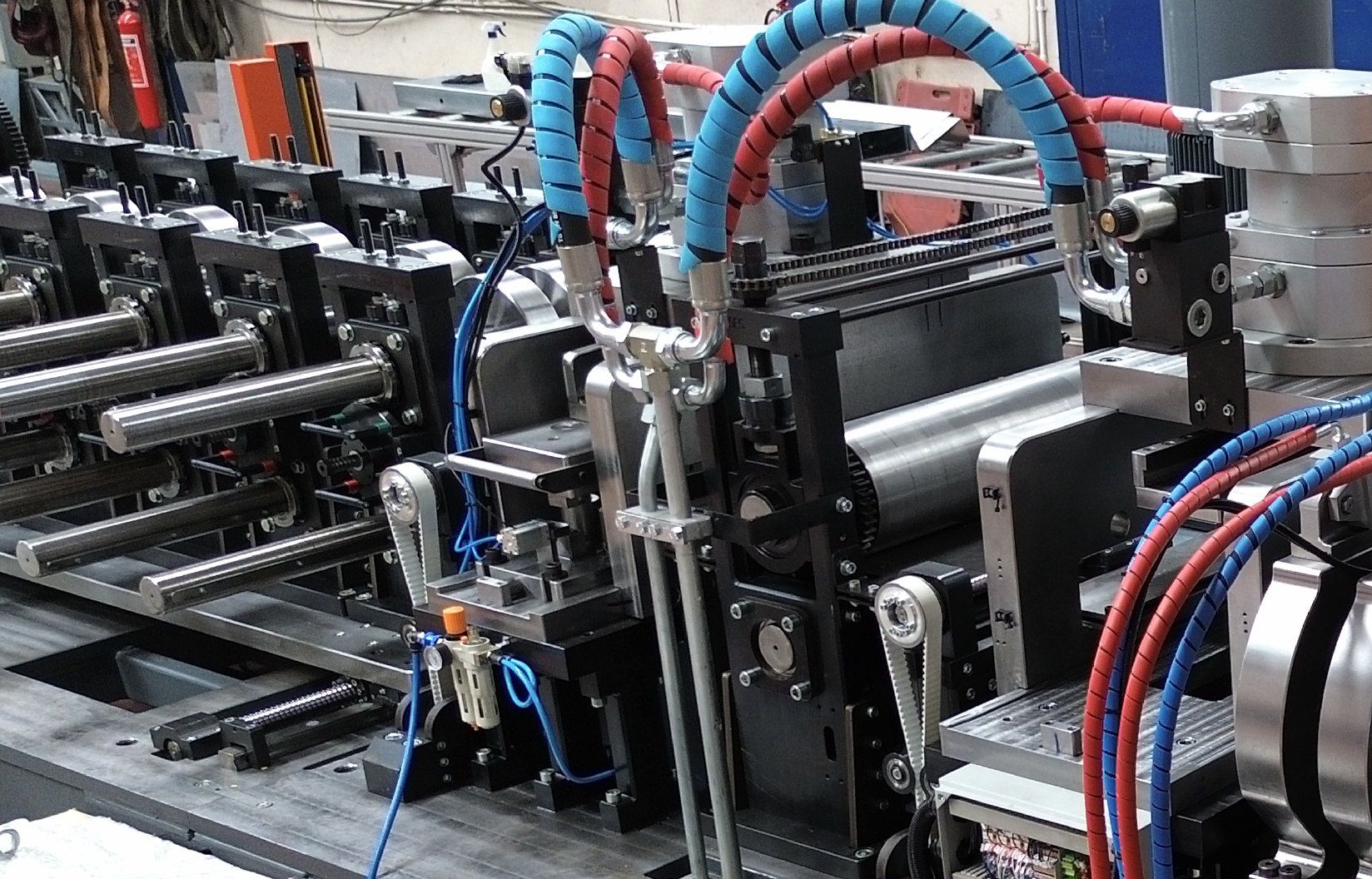 Stacked C-section purlins beside an automated roll-forming line